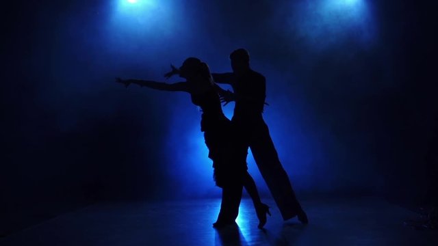 Silhouette of pair dancers performing modern dance in slow motion