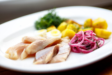 Herring sliced with red onions and boiled potatoes.