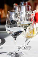 A glass of white wine stands on the table in the restaurant.