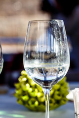 A glass of white wine stands on the table in the restaurant.