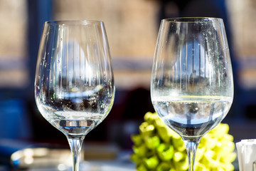 A glass of white wine stands on the table in the restaurant.