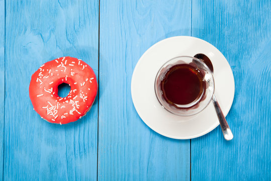 Cup of tea and donuts on a blue wooden table