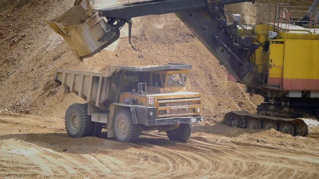 A mining excavator produces sand loading in a truck body