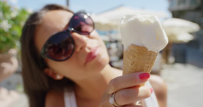 Young woman eating ice cream on beach Girl licking Italian Gelato outdoors in summer sunshine enjoying European vacation travel adventure Amalfi Coast Positano Italy