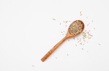 Fennel fruits in a wooden spoon on a white