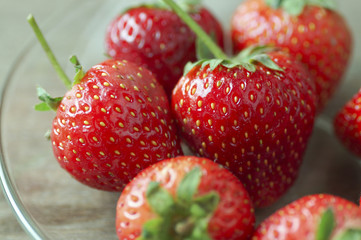 Fresh strawberries on wooden table with low key scene.