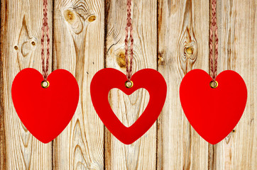 Three red hearts on the wooden weathered rustic background