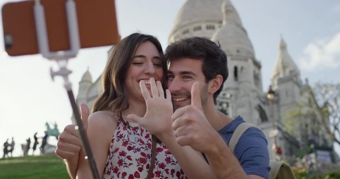 Tourist couple taking selfie photograph Thumbs up Sacre Coeur Paris with smartphone in city enjoying summer holiday European vacation travel adventure 