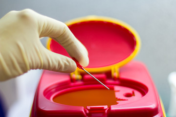 a hand takes a needle in a medical bin