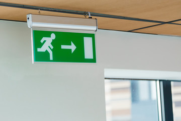 Sign "exit direction" hanging on the ceiling in the office