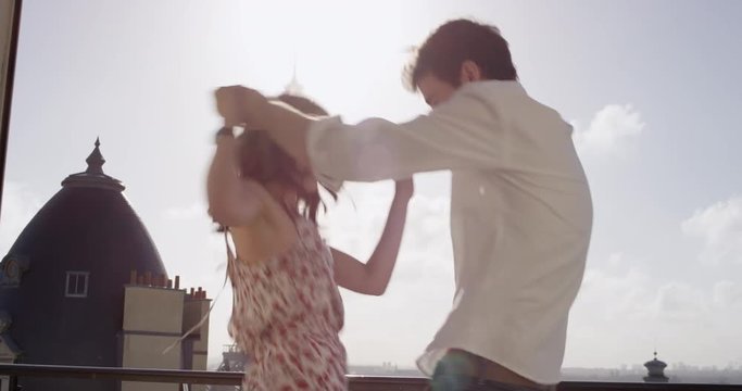 Happy tourist couple dancing silly freestyle dance in Paris in front of Eiffel Tower enjoying vacation celebrating honeymoon travel adventure