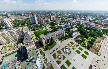 Aerial city view with crossroads and roads, houses, buildings, parks and parking lots, bridges. Copter shot. Panoramic image.