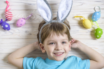 Easter concept. Happy cute child wearing bunny ears getting ready for Easter