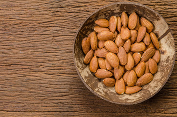 almond in wooden bowl on wooden board