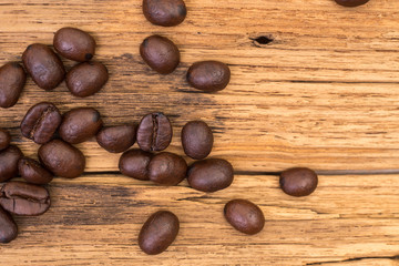 Roasted coffee beans on wood texture background. vintage color effected