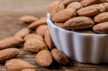 almond in porcelain bowl on wooden board