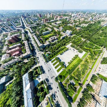 Aerial city view with crossroads, roads, houses, buildings, parks and parking lots. Copter drone helicopter shot. Panoramic wide angle image.