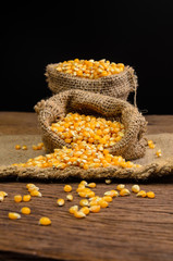 Dried corn in sackbag on wooden table