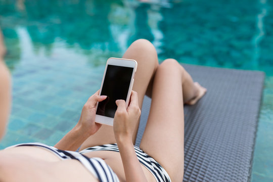 Woman use of smart phone in swimming pool