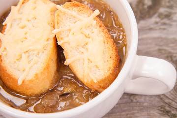 Onion soup with toast on a wooden background