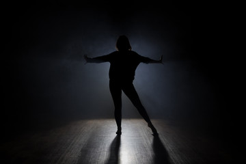 Dancer posing in the dark and smoke