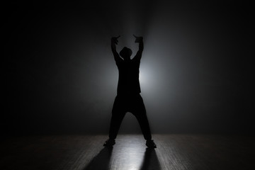 Fototapeta na wymiar Man dancer posing in the dark and smoke