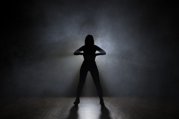 Hip-hop dancer posing backlit.