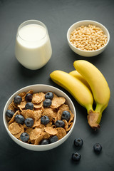 Healthy food. Milk, multi grain flakes with blueberry, nuts and bananas for breakfast.