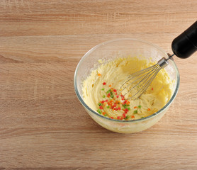 mixing dough for cake in a bowl with candied fruit