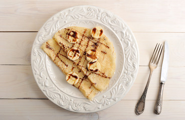 pancakes with banana and chocolate on a plate