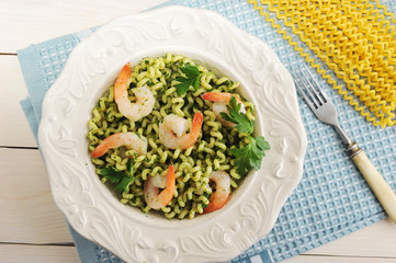 pasta with shrimp and spinach in a bowl and ingredients for cooking pasta