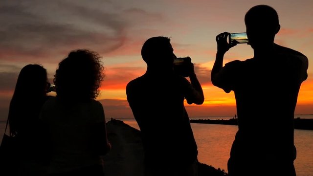 Teenagers Group Taking Photos of Amazing Beach Sunset on Mobile Phone. People Silhuette Using Gadgets HD Slowmotion.