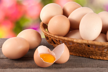 eggs in a wicker basket on a wooden board with blurred garden background