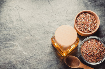 linseed oil in bottle and flax seeds on table