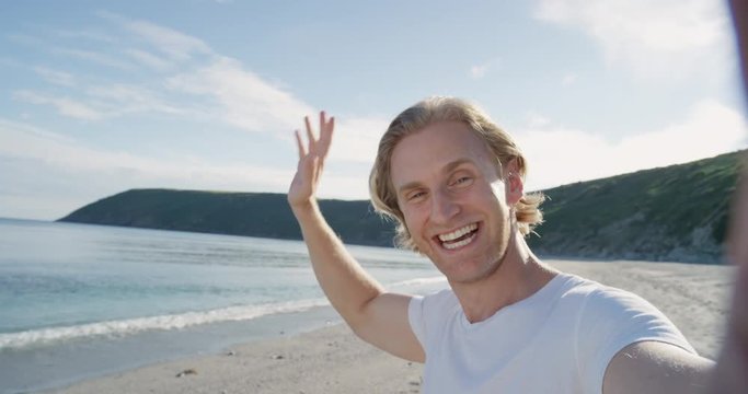 Man taking selfie using phone on beach at sunset smiling enjoying nature and lifestyle on vacation