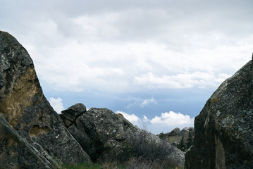 Wonderful nature. Rocky land, high mountains, dramatic cloudy sky. Spring landscape.