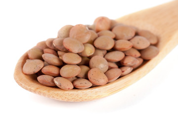 Lentils in a wooden spoon isolated on a white background