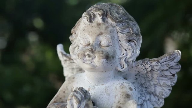 praying stone angel on rotating plate
