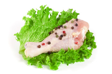one raw chicken drumstick with lettuce leaf isolated on white background