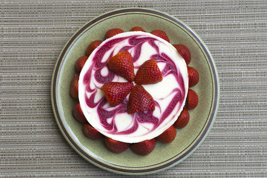 Pastel elaborado con queso y decorado con fresones frescos.