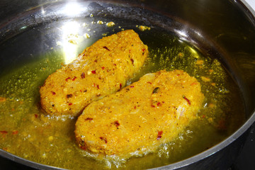 Catfish steaks being fried in oil