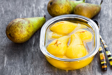 Poached  pears with spices in syrup on the glass bowl © lena_zajchikova