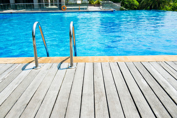 Fototapeta premium Swimming pool with stair and wooden deck at hotel.