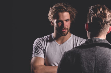 Two handsome men standing with faces opposite