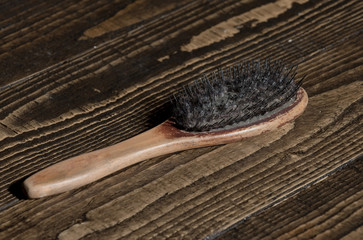 Old wooden hairbrush with dirty bristles