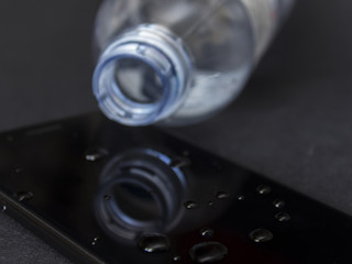 Water spilled from a bottle onto a smartphone