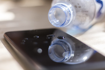 Water spilled from a bottle onto a smartphone