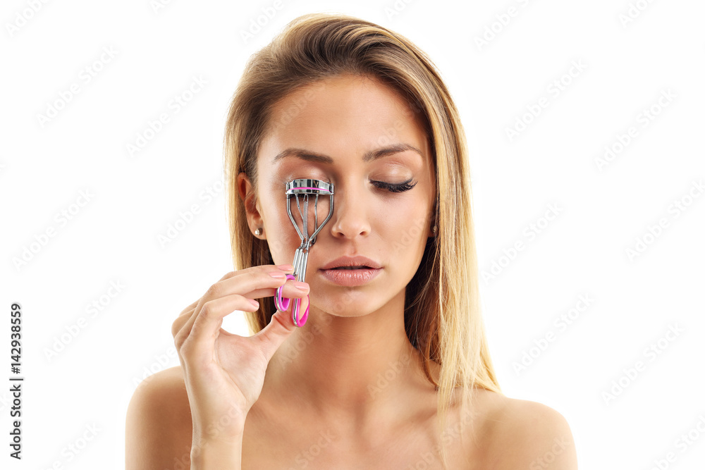 Wall mural picture showing woman using eyelash curler over white