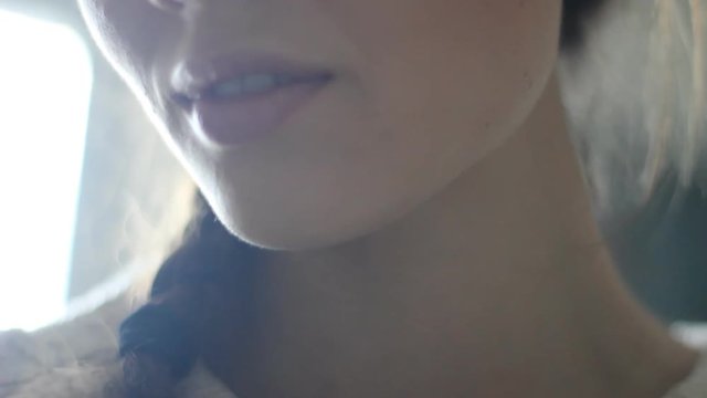 Big close up of young woman's face smiling. Fashionable knitted sweater of milky bedding. Graceful thin neck of an attractive girl. Cleansing a gentle smile on my face and a slow turn of the head