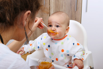 Mother feeding her baby solids